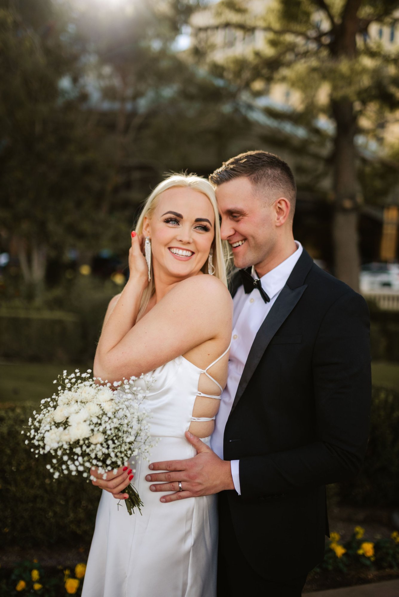 Bride and groom portrait with bouquet in garden
