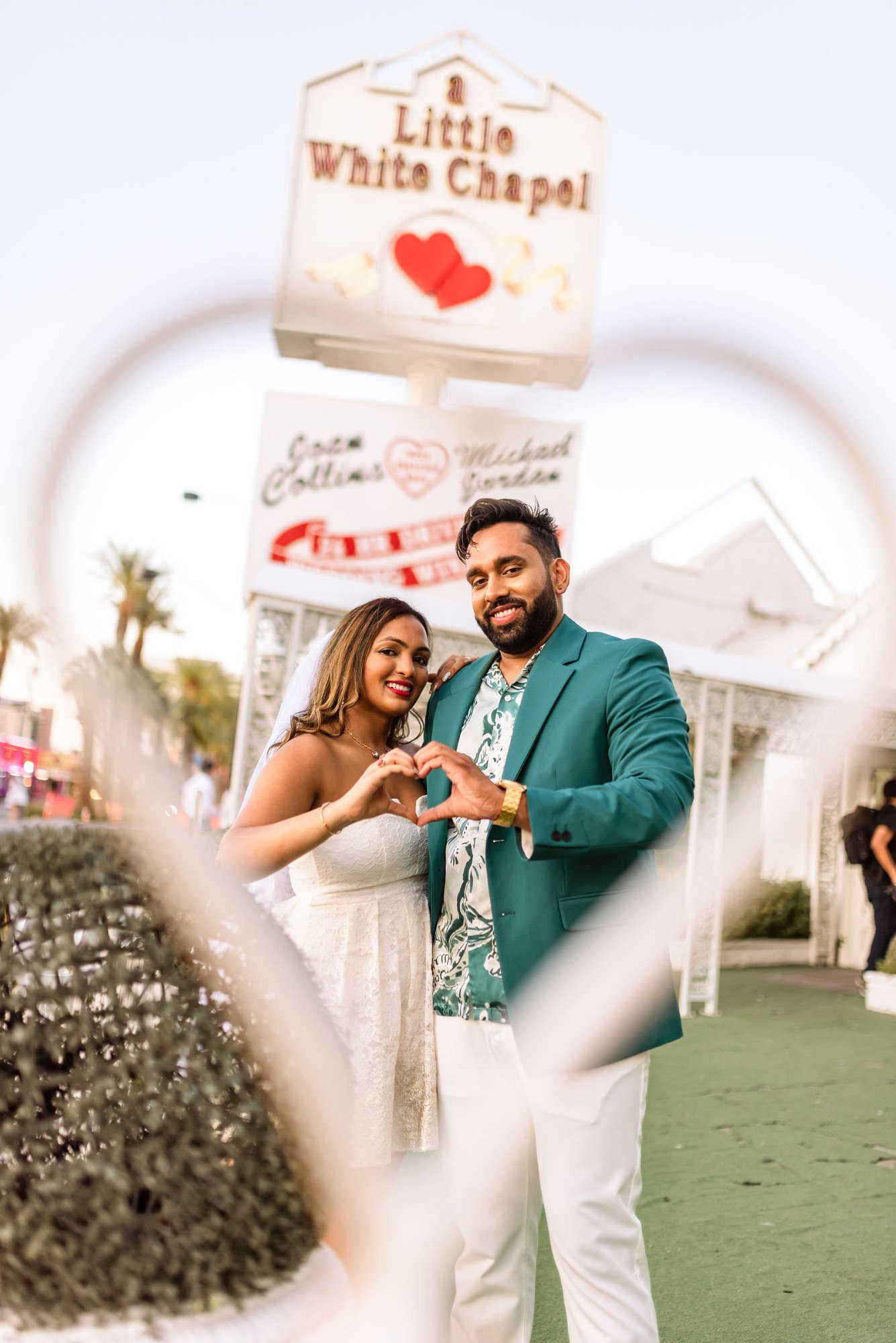 Couple making heart hands at Little White Wedding Chapel