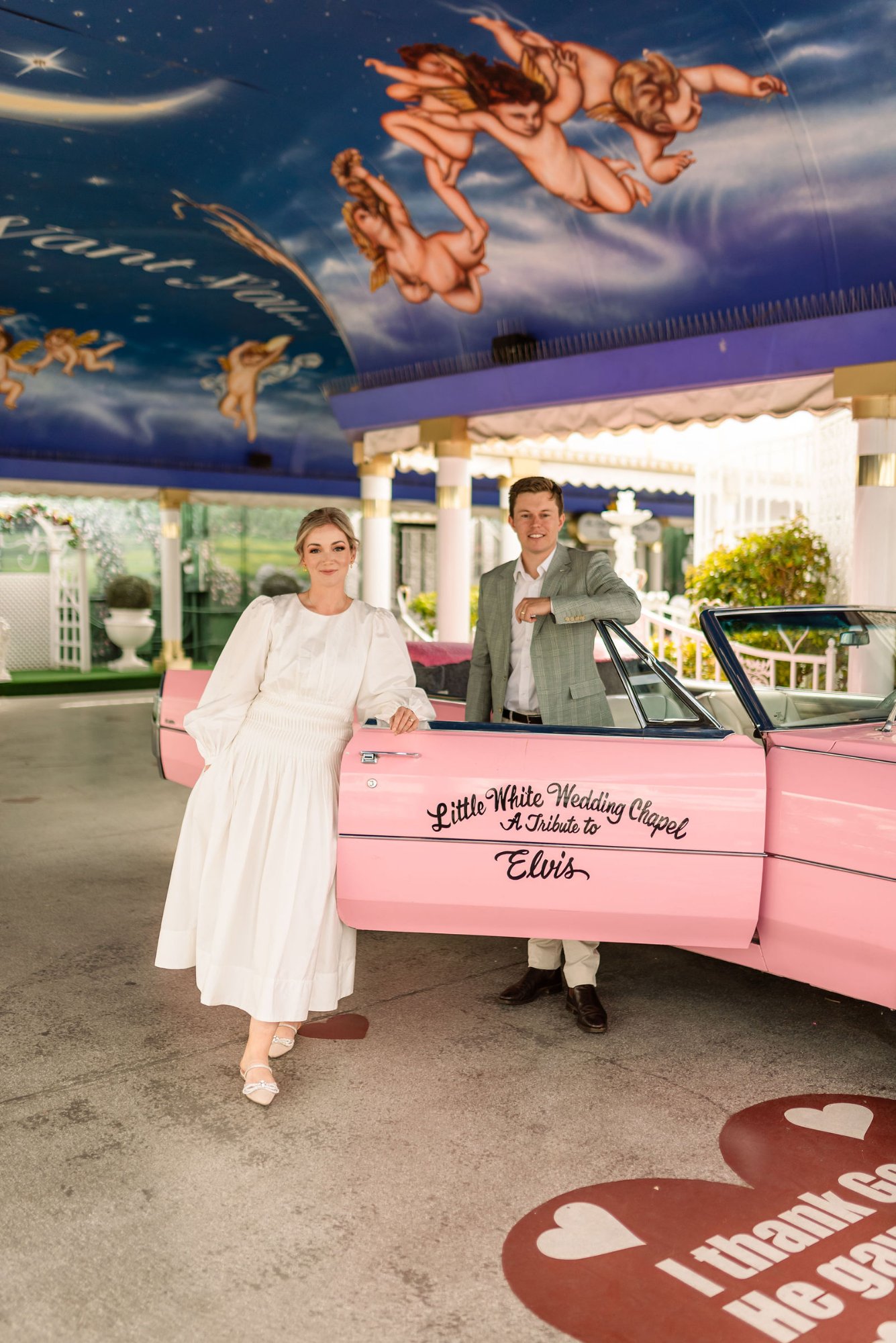 Couple at Little White Wedding Chapel with pink Cadillac - Las Vegas elopement