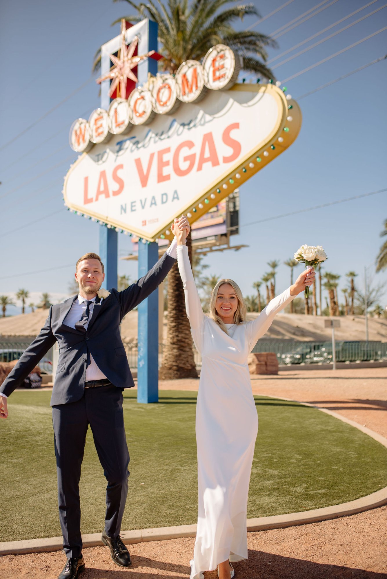 Newlywed couple celebrating at the Welcome to Las Vegas sign